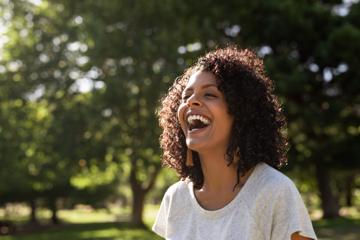 WellMind Therapy - woman laughing out doors, feeling free